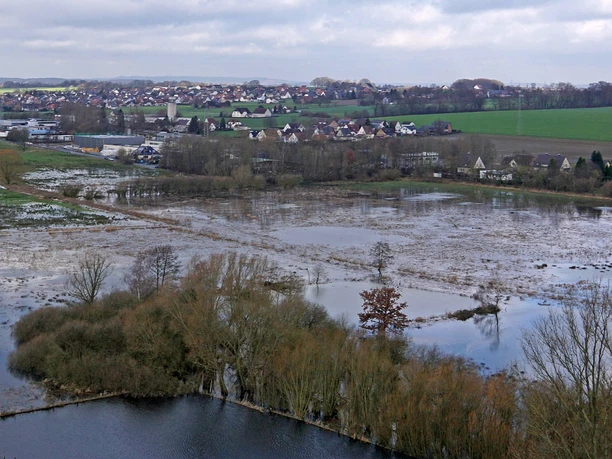 NSG Engerbruch oben Luftaufnahme eines überfluteten Naturschutzgebiets mit Feldern, Bäumen und einer angrenzenden Stadt.