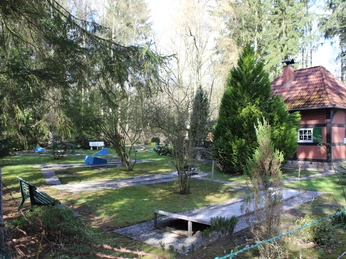 Minigolfplatz Kurpark Minigolfplatz im Kurpark mit klassisch gestalteten Bahnen, von Bäumen umgeben, neben Holzhaus.