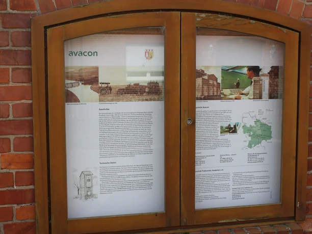Trafohäuschen Anderten Eine Infotafel in einem Holzrahmen mit Details über die Geschichte und Technik des Trafohäuschens.