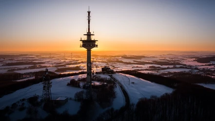 Sonnenaufgang am Köterberg (Luftaufnahme) Luftaufnahme eines strahlend goldenen Sonnenaufgangs am schneebedeckten Köterberg mit Fernmeldeturm.