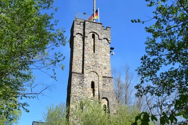 Haldyturm Der Steffenshammer-Turm in Engelskirchen, umgeben von Bäumen, gegen einen klaren blauen Himmel.