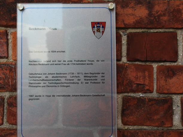 Commemorative plaque on a brick wall providing information about the historic Beckmann House from 1504.
