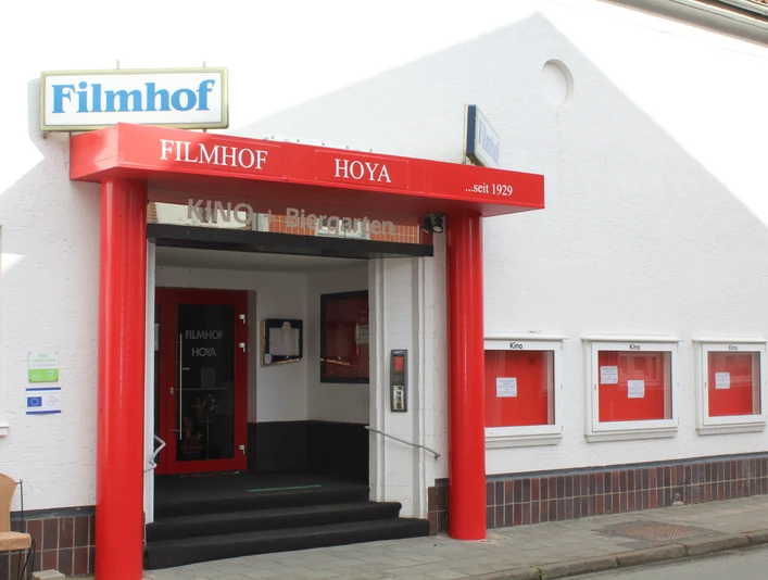 Filmhof Hoya Filmhof Hoya mit roter Fassade und Markise, Kinotafeln, begehbarer Eingang.