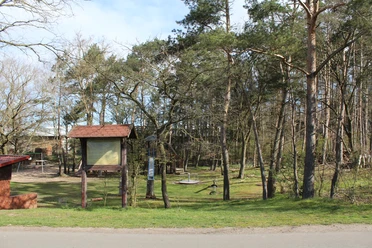 Grabhügelfeld Calle Beschilderter Eingangsbereich zu einem archäologischen Grabhügelfeld mit umliegenden Bäumen und Wald.