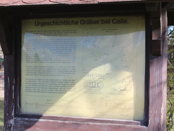 Informationsschild über das Grabhügelfeld in Calle, mit Texten zur prähistorischen Geschichte und Skizzen.