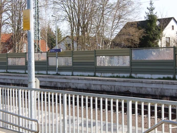 Bahnhof Eystrup Ein ruhiger Bahnhof in Eystrup mit leeren Gleisen, modernen Zäunen und umliegenden Wohnhäusern.