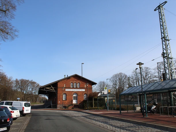 Güterschuppen Eystrup Güterschuppen Eystrup, ein historisches Backsteingebäude nahe einer ruhigen Straße mit parkenden Autos.