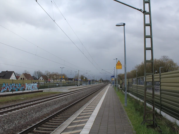 Bahnhof Langwedel-Etelsen Zwei parallel verlaufende Bahngleise am Bahnhof Langwedel-Etelsen, flankiert von Soundwänden.