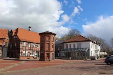 Rathaus Thedinghausen Rathaus Thedinghausen mit Fachwerkbauelementen und prägnantem quadratischem Eckturm bei blauem Himmel.