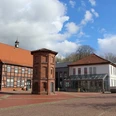 Rathaus Thedinghausen Rathaus Thedinghausen mit Fachwerkbauelementen und prägnantem quadratischem Eckturm bei blauem Himmel.