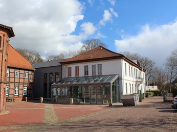 Historisches Backstein-Rathaus in Thedinghausen mit modernen Anbauten und gepflastertem Vorplatz.