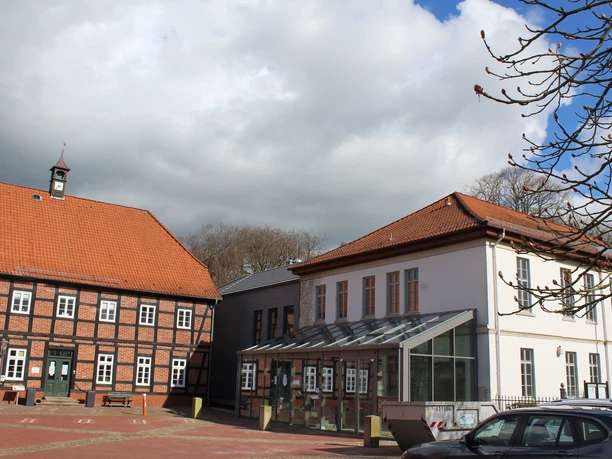 Rathaus Thedinghausen Historisches Gebäudeensemble mit Fachwerk-Rathaus und modernem Anbau, unter teils bewölktem Himmel.