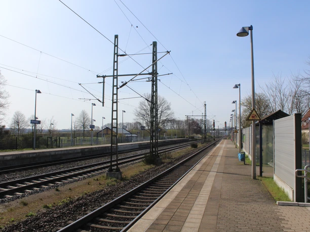 Der Bahnhof Dörverden zeigt Bahnsteige mit Gleisen, Oberleitungen und eine ruhige ländliche Umgebung.