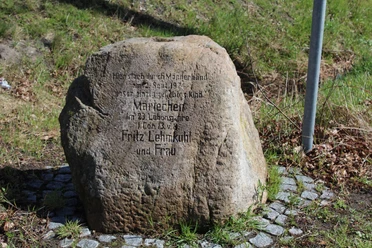 Gedenkstein zu Ehren von Mariechen Lehmkuhl, umgeben von Pflastersteinen auf grasbewachsenem Untergrund.