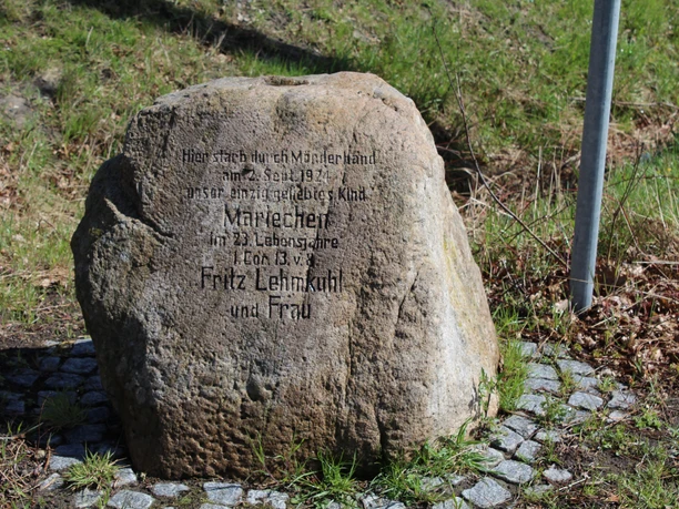Gedenkstein Mariechen Lehmkuhl Gedenkstein zu Ehren von Mariechen Lehmkuhl, umgeben von Pflastersteinen auf grasbewachsenem Untergrund.