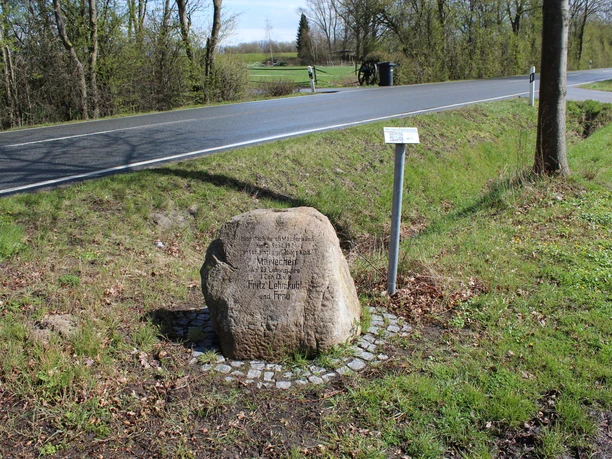Gedenkstein Mariechen Lehmkuhl Gedenkstein Mariechen Lehmkuhl am Wegesrand mit Straßen- und Landschaftskulisse im Hintergrund.