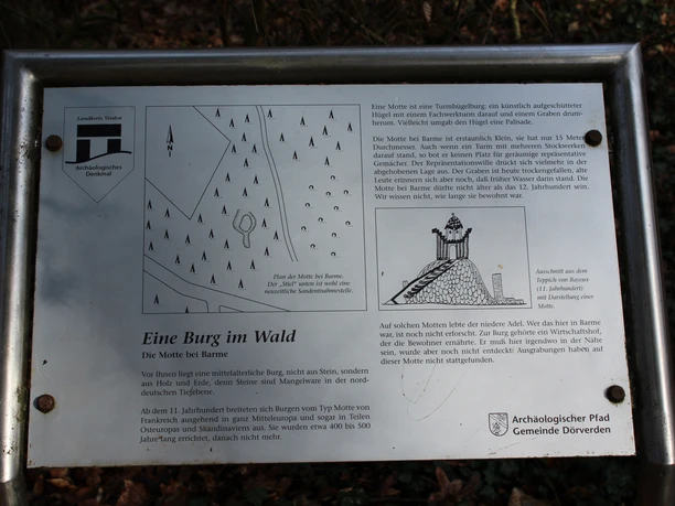 Eine Tafel im Wald zeigt eine Skizze und Informationen zur historischen Burganlage Barmer Motte.