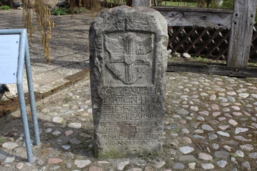 Schnedenstein Diensthop Steinmonument mit Wappen und Inschrift, umgeben von Pflastersteinen, im Außenbereich aufgenommen.