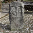 Schnedenstein Diensthop Steinmonument mit Wappen und Inschrift, umgeben von Pflastersteinen, im Außenbereich aufgenommen.