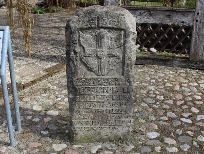 Schnedenstein Diensthop Steinmonument mit Wappen und Inschrift, umgeben von Pflastersteinen, im Außenbereich aufgenommen.