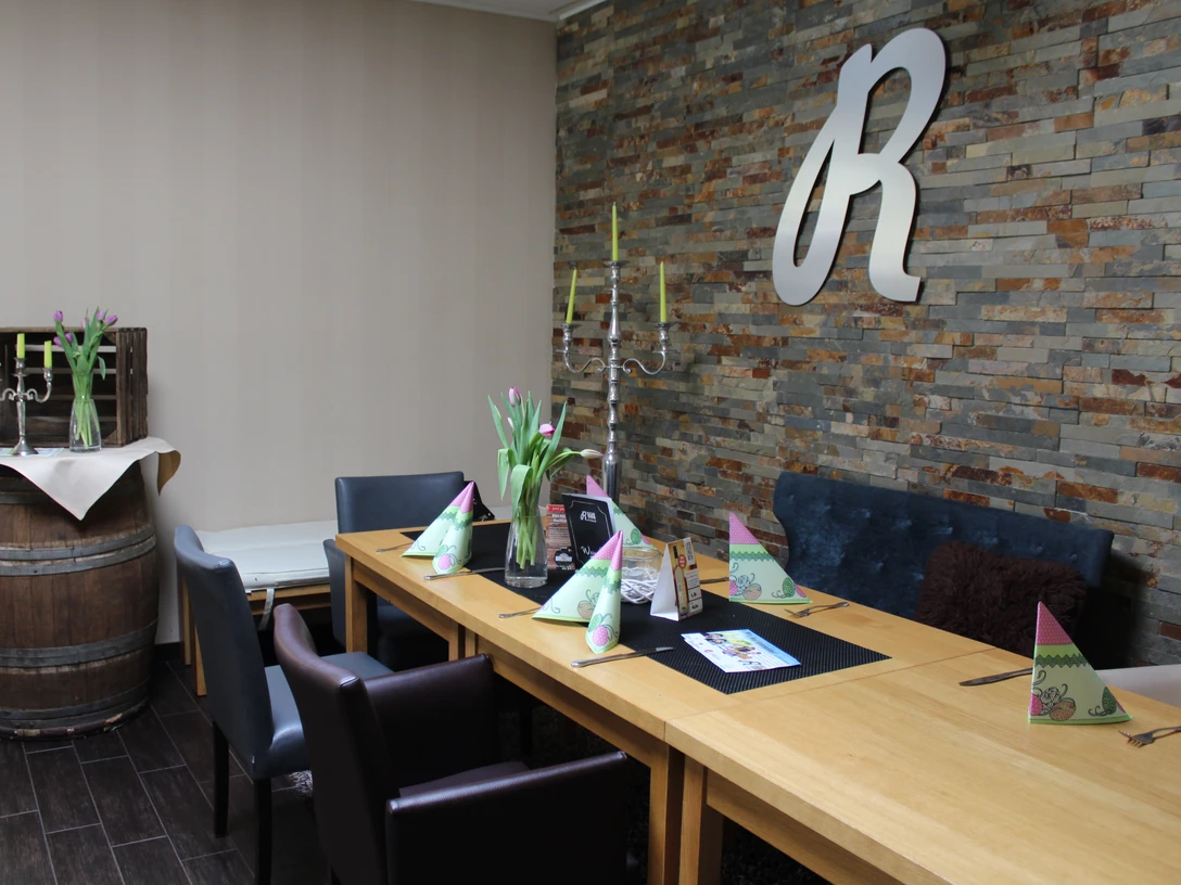 Gasthaus Rohrbach Ein stilvoll gedeckter Essbereich mit Tulpenblumen und einer rustikalen Steinwand in einem Gasthaus.A stylish dining area with tulip flowers and a rustic stone wall in an inn.En stilfuld spiseplads med tulipanblomster og en rustik stenvæg på en kro.Een stijlvolle eethoek met tulpenbloemen en een rustieke stenen muur in een herberg.