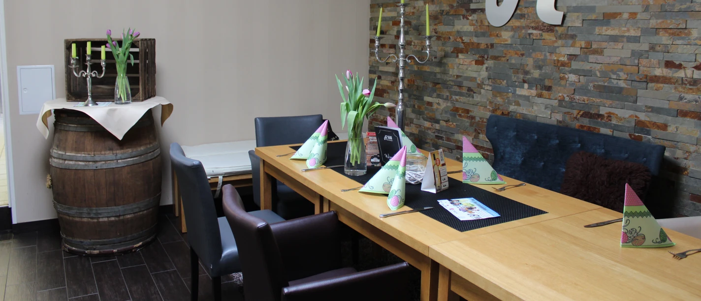 Gasthaus Rohrbach Ein stilvoll gedeckter Essbereich mit Tulpenblumen und einer rustikalen Steinwand in einem Gasthaus.