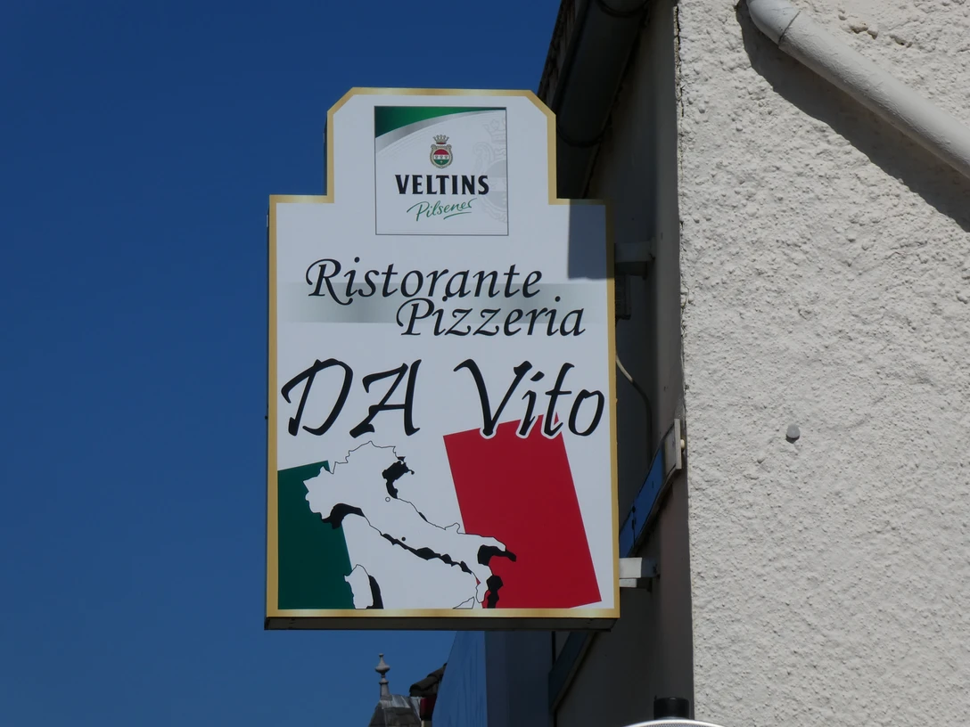 Ein Schild mit der Aufschrift "Ristorante Pizzeria DA Vito" und einer Italienkarte im Hintergrund.A sign with the words "Ristorante Pizzeria DA Vito" and a map of Italy in the background.Et skilt med ordene "Ristorante Pizzeria DA Vito" og et kort over Italien i baggrunden.Een bord met de woorden "Ristorante Pizzeria DA Vito" en een kaart van Italië op de achtergrond.