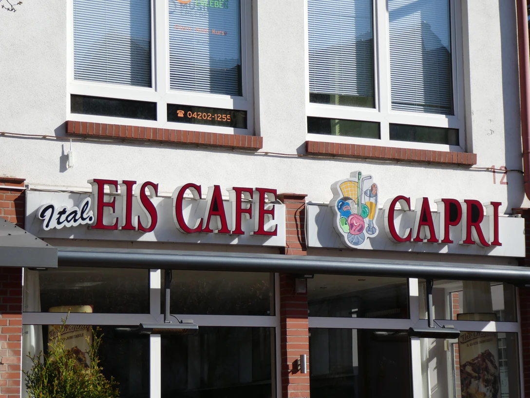 Eiscafé Capri Der Eingang des Eiscafé Capri mit seiner markanten Beschilderung in Rot und einem Eiskremsymbol.