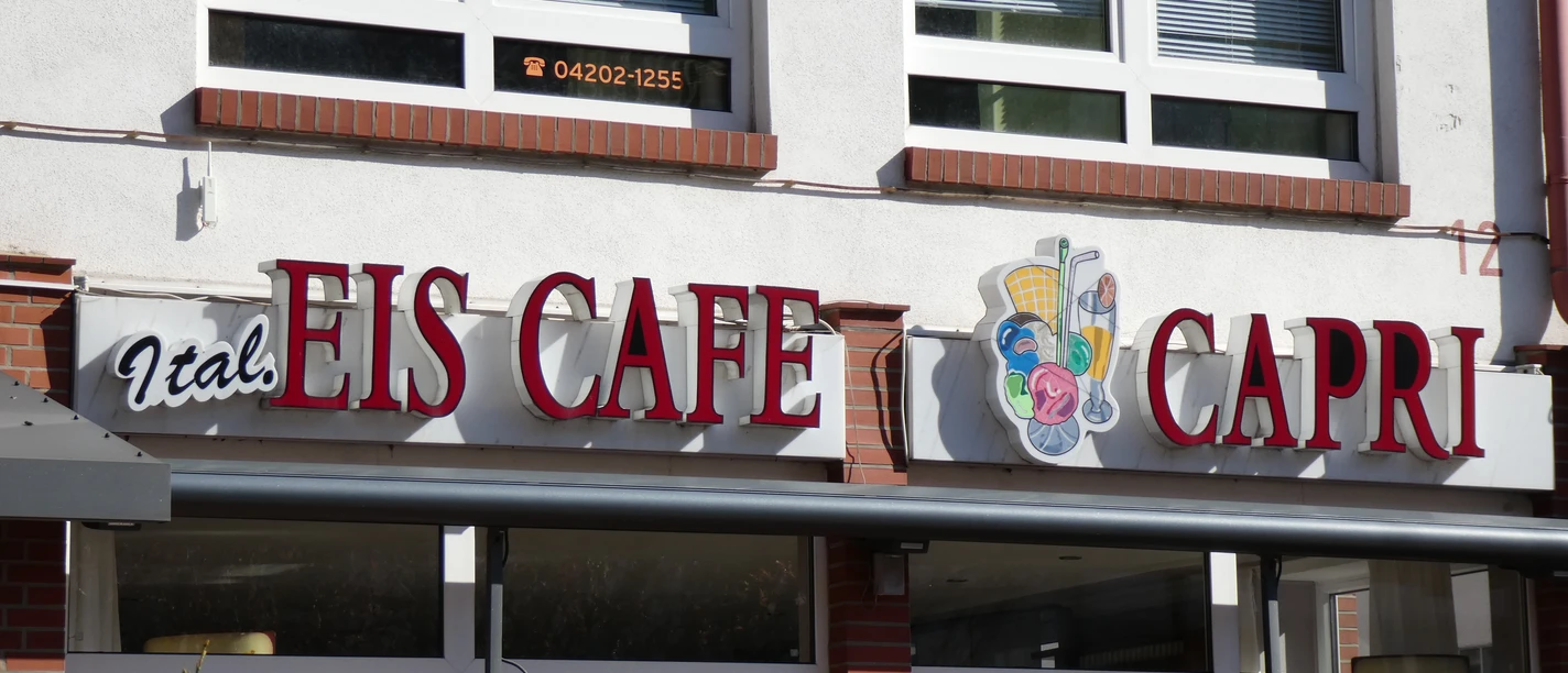 Eiscafé Capri Der Eingang des Eiscafé Capri mit seiner markanten Beschilderung in Rot und einem Eiskremsymbol.