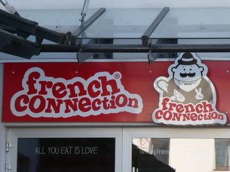 French Connection Eingangsbereich eines Restaurants mit dem Namen "French Connection" und einem Cartoon-Koch als Logo.