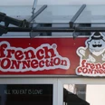 French Connection Eingangsbereich eines Restaurants mit dem Namen "French Connection" und einem Cartoon-Koch als Logo.