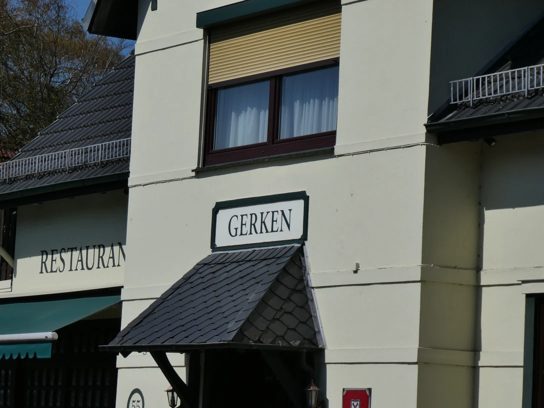 Gasthaus Gerken mit traditioneller Fassade und einladendem Vordach unter blauem Himmel.