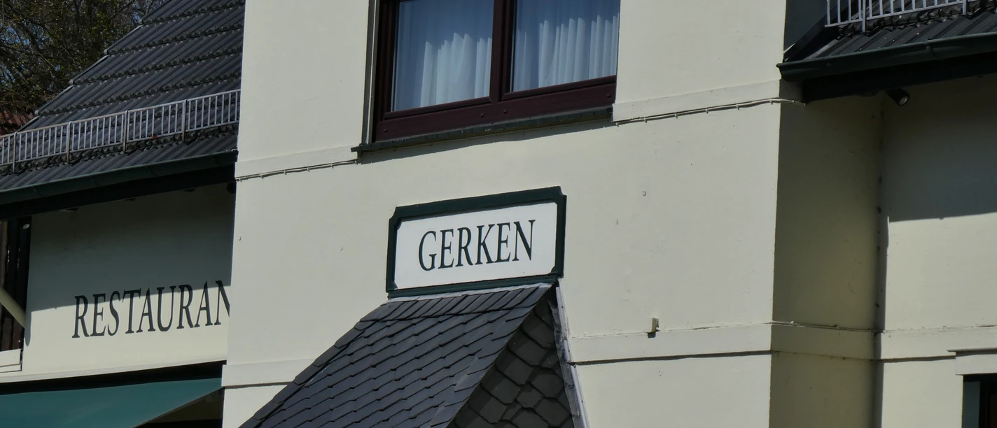 Gasthaus Gerken met zijn traditionele gevel en uitnodigende luifel onder een blauwe hemel.