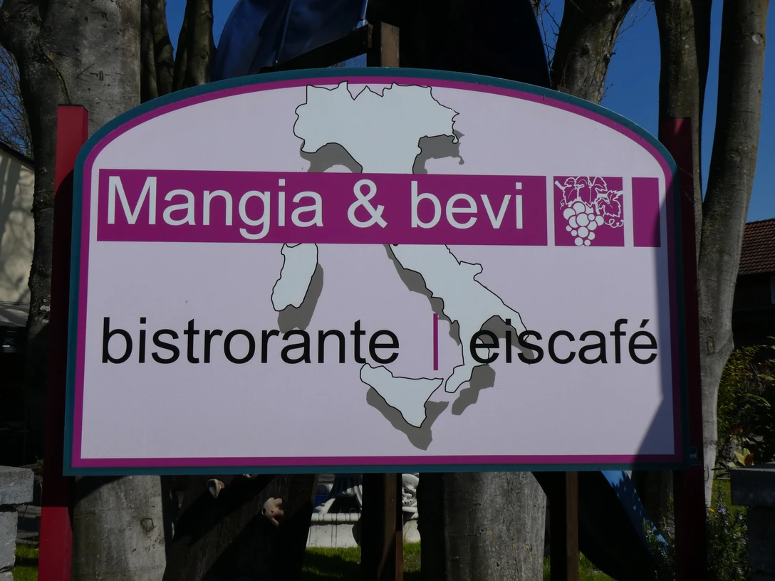 Mangia & Bevi Mangia & Bevi Bistroschild mit Karte Italiens, Holzrahmen und laubumrahmtem Hintergrund.