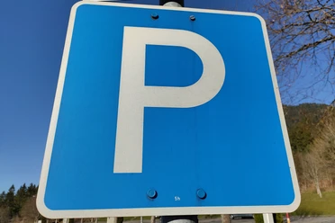 Parkplatz Blaues Verkehrsschild mit weißem "P", das einen Parkplatz kennzeichnet.