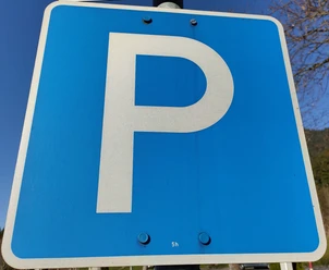 Parkplatz Schild Blaues Verkehrsschild mit einem weißen "P" für Parkplatz auf einem Metallpfosten.