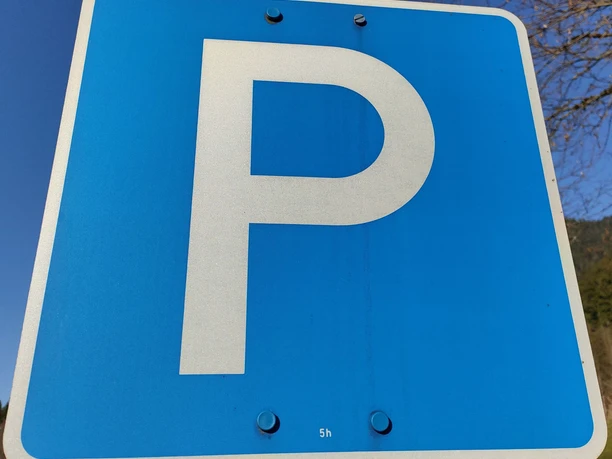 Parkplatz Schild Blaues Verkehrsschild mit einem weißen "P" für Parkplatz auf einem Metallpfosten.