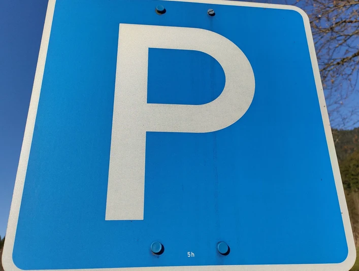 Parkplatz Schild Blaues Verkehrsschild mit einem weißen "P" für Parkplatz auf einem Metallpfosten.