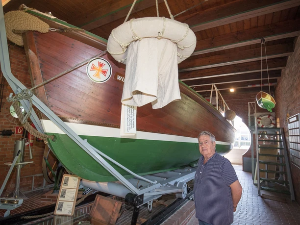 Teddy Rohde, ehrenamtlicher Mitarbeiter der Deutschen Gesellschaft zur Rettung Schiffbruechiger (DGzRS) im historischen Rettungsschuppen Fedderwardersiel mit dem Motorrettungsboot WILHELMINE WIESE