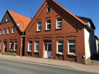 Backsteingebäude mit Satteldach und mehreren Fenstern, gelegen an einer gepflasterten Straße in Rehburg.