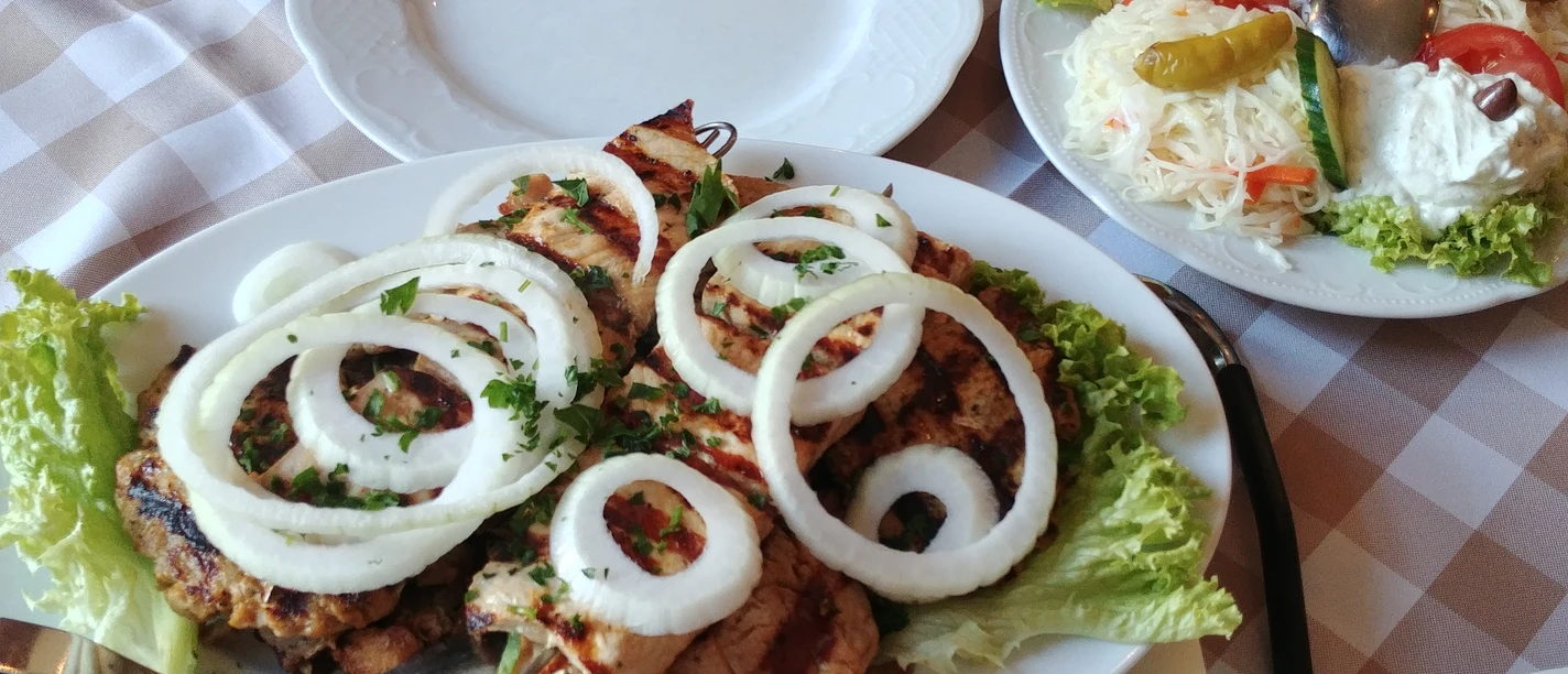 griechische Fleischplatte Griechische Fleischplatte mit gegrilltem Fleisch, frischen Zwiebelringen und Beilagensalat.