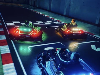 Startaufstellung II.jpg Beim nächtlichen Go-Kart-Fahren sind drei Fahrer in leuchtenden Karts bei einem spannenden Rennen zu sehen.