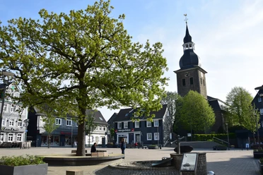 Marktplatz <p>Ein Baum und eine Kirche prägen den Marktplatz mit historischen Fachwerkhäusern in Radevormwald.</p>