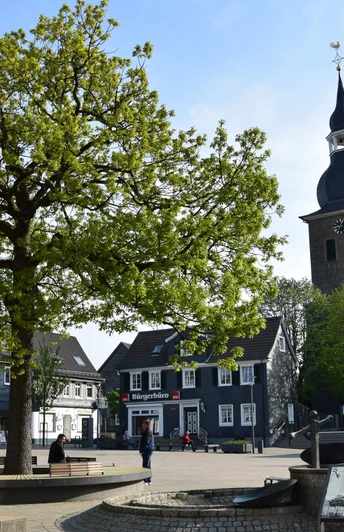 Marktplatz <p>Ein Baum und eine Kirche prägen den Marktplatz mit historischen Fachwerkhäusern in Radevormwald.</p>