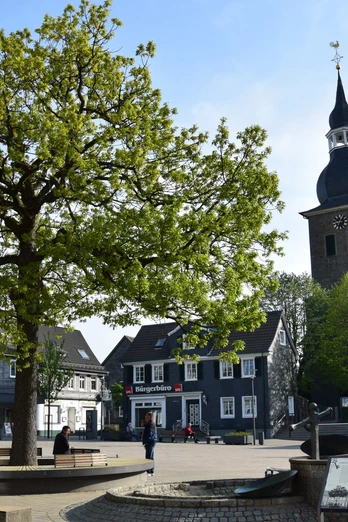 Marktplatz <p>Ein Baum und eine Kirche prägen den Marktplatz mit historischen Fachwerkhäusern in Radevormwald.</p>