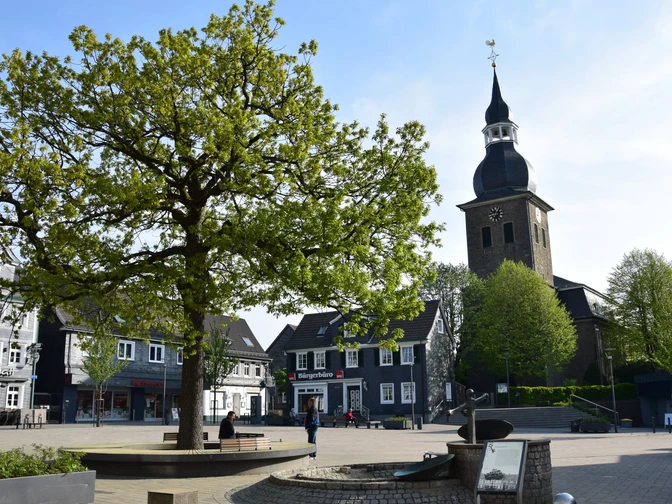 Marktplatz <p>Ein Baum und eine Kirche prägen den Marktplatz mit historischen Fachwerkhäusern in Radevormwald.</p>