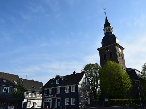 Marktplatz Der Marktplatz in Radevormwald mit Kirche im Vordergrund und blauen Häusern unter blauem Himmel.