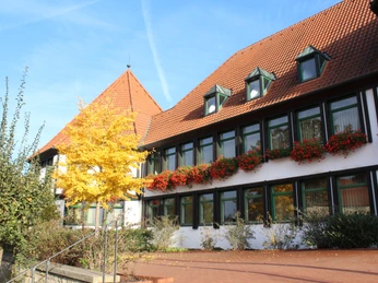 Das Rathaus Rehburg präsentiert sich mit Fachwerkfassade, roten Dachziegeln und herbstlichem Baum.