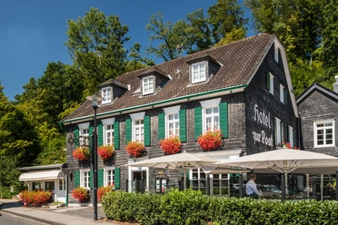Hotel Zur Post Altes Fachwerkhotel mit grünen Fensterläden und blühenden Blumen in sonniger Umgebung.
