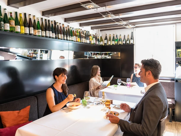 Hotel Zur Post <p>Ein stilvolles Restaurant mit Gästen, die sich an weiß gedeckten Tischen unterhalten und speisen.</p>